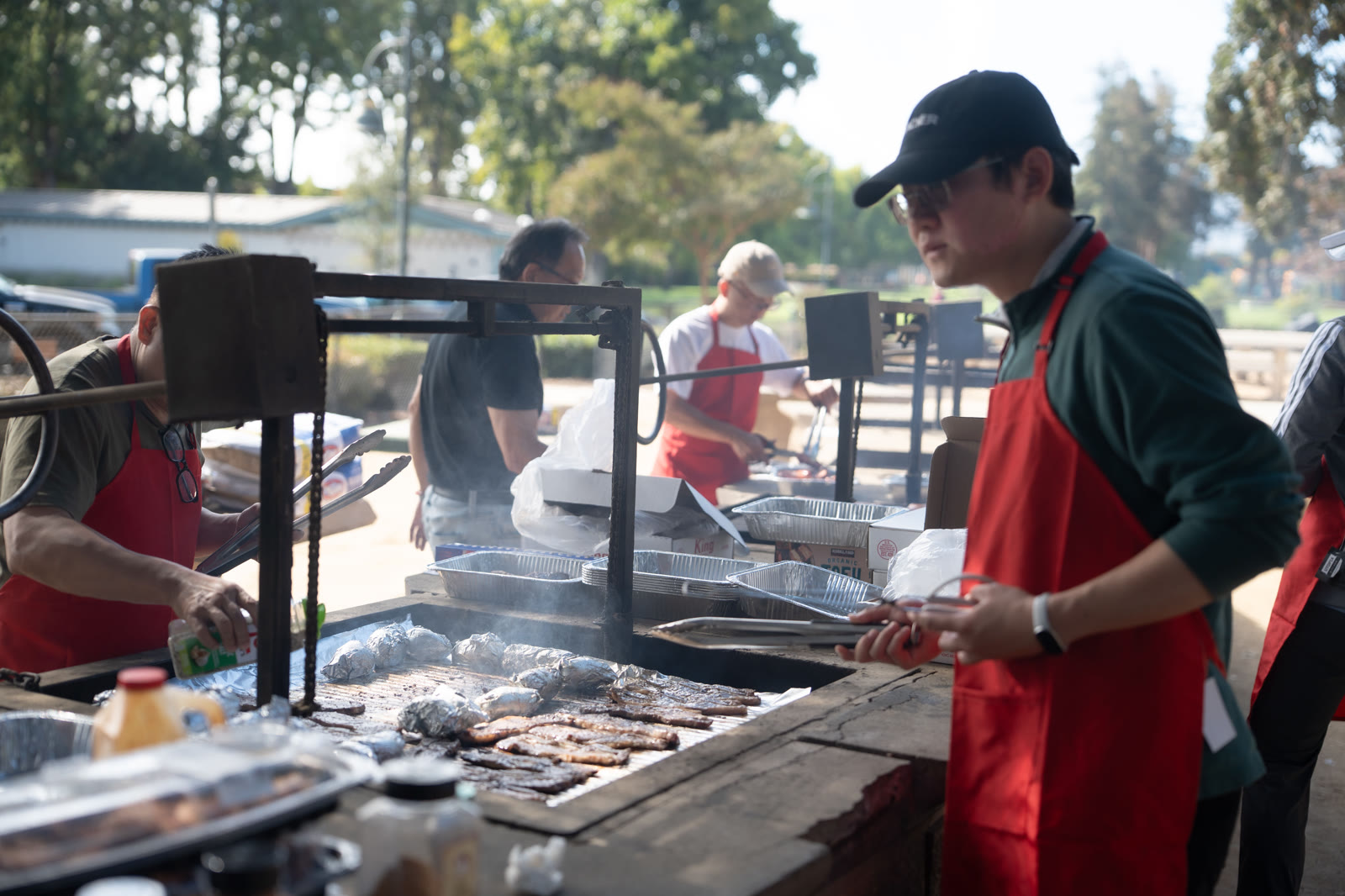 Volunteers tend the barbecue grill at Rengstorff Park.
