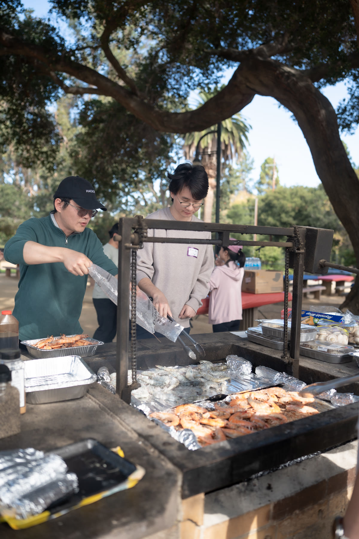 Volunteers prepare food beside the picnic tables.